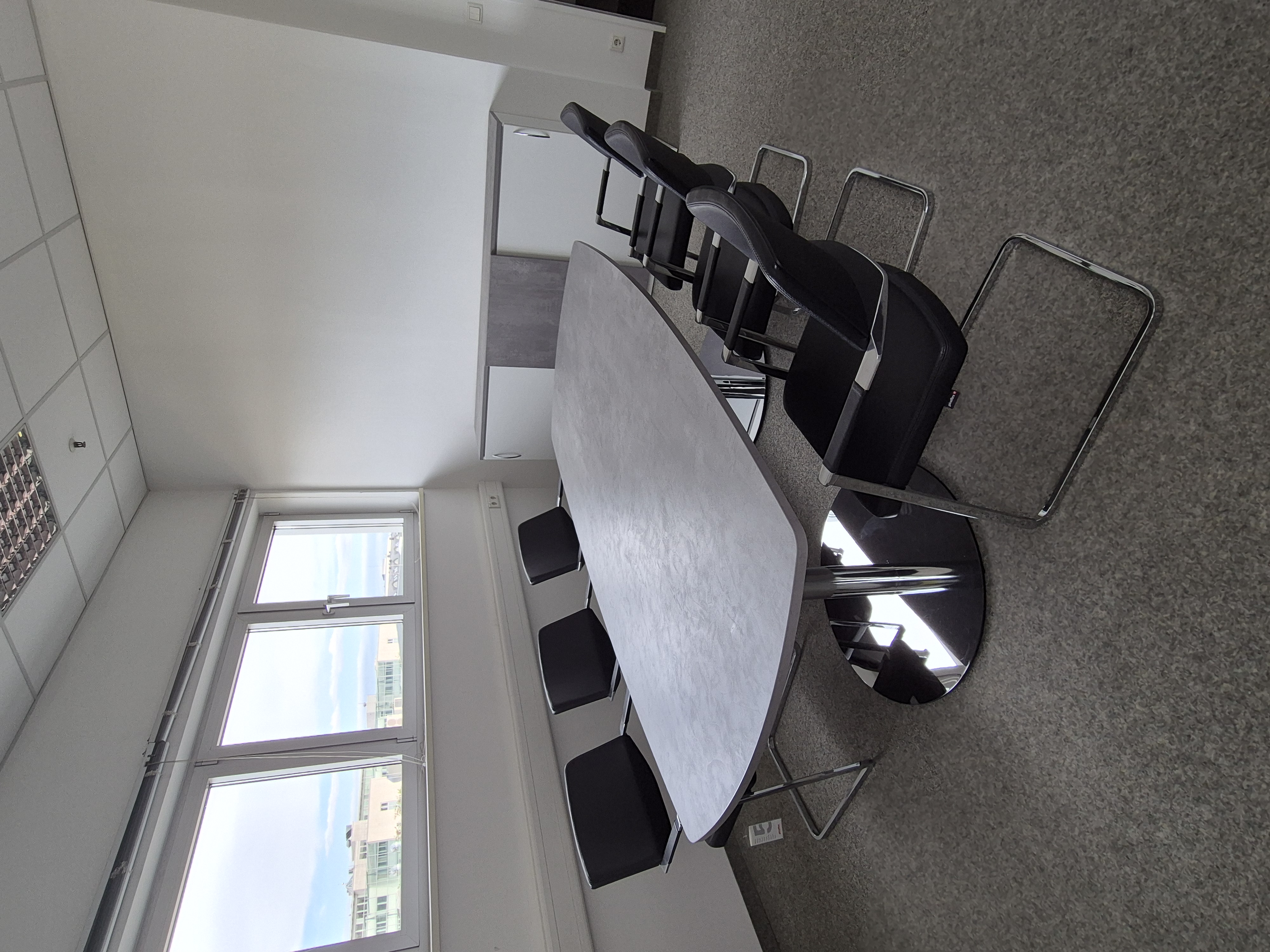 Konferenzraum mit Tisch, Stühlen und Sideboard