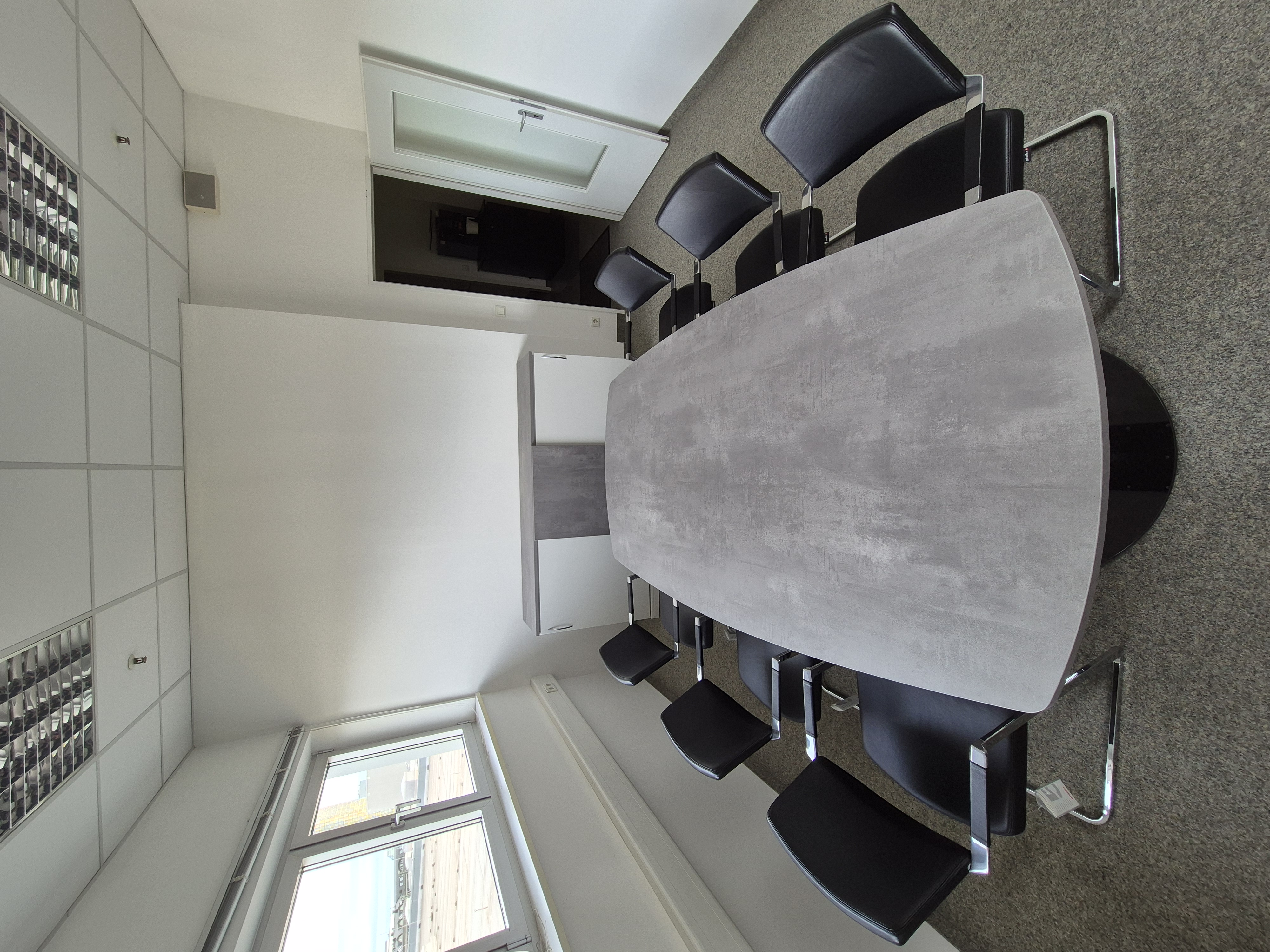 Konferenzraum mit Tisch, Stühlen und Sideboard